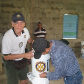 Jack Maxwell showing a village member how to assemble the filter to bucket and how to back wash the filter